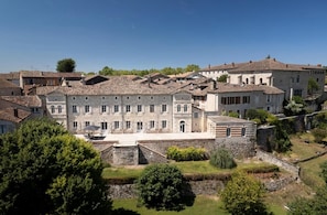 A historic stone building with multiple windows and a courtyard. - les Trois Terrasses (Montpezat-de-Quercy)