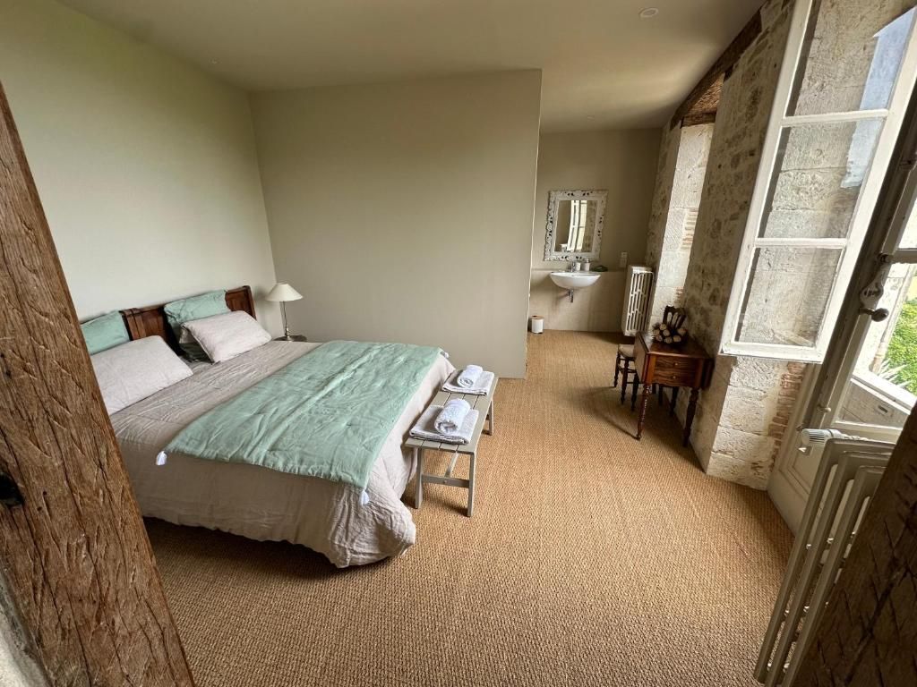 Una camera da letto con un letto, comodini, una lampada, uno specchio, una finestra e una porta.