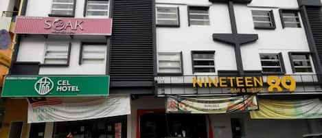 Un edificio de varios pisos que alberga diversos comercios, incluyendo un hotel, un bar y un restaurante.