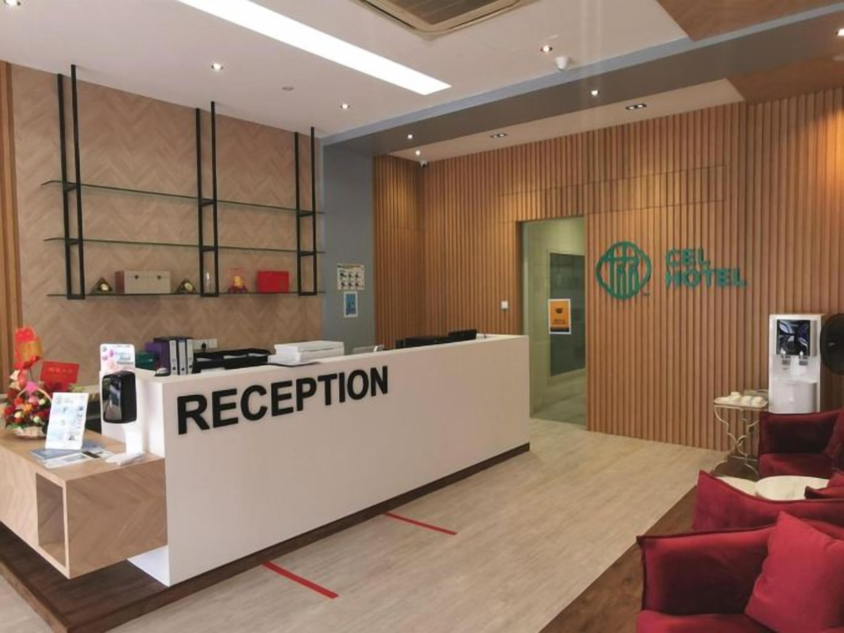 A reception area with a reception desk, a wooden wall, and a logo on the wall.