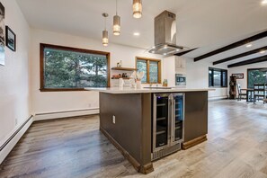 A modern kitchen with a large island, built-in appliances, and a view of the outdoors. - Golf Course Retreat | Hot Tub, Mtn Views, 5BR (Estes Park)
