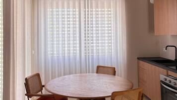 Une cuisine moderne avec une table de salle à manger ronde, des chaises et un luminaire suspendu.