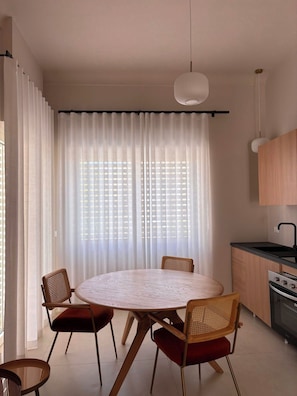 Una cucina moderna con un tavolo rotondo, sedie e una lampada a sospensione.