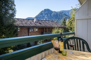 Une cabane en bois dotée d’un balcon donnant sur un paysage montagneux.