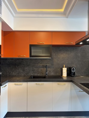 A modern kitchen with a built-in oven, a sink, and a coffee machine. - Larimar Luxury Seafront Apartment with Jacuzzi (Iż-Żebbuġ)