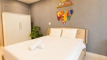 Una habitación de hotel moderna con una cama grande, un armario y una decoración en la pared.