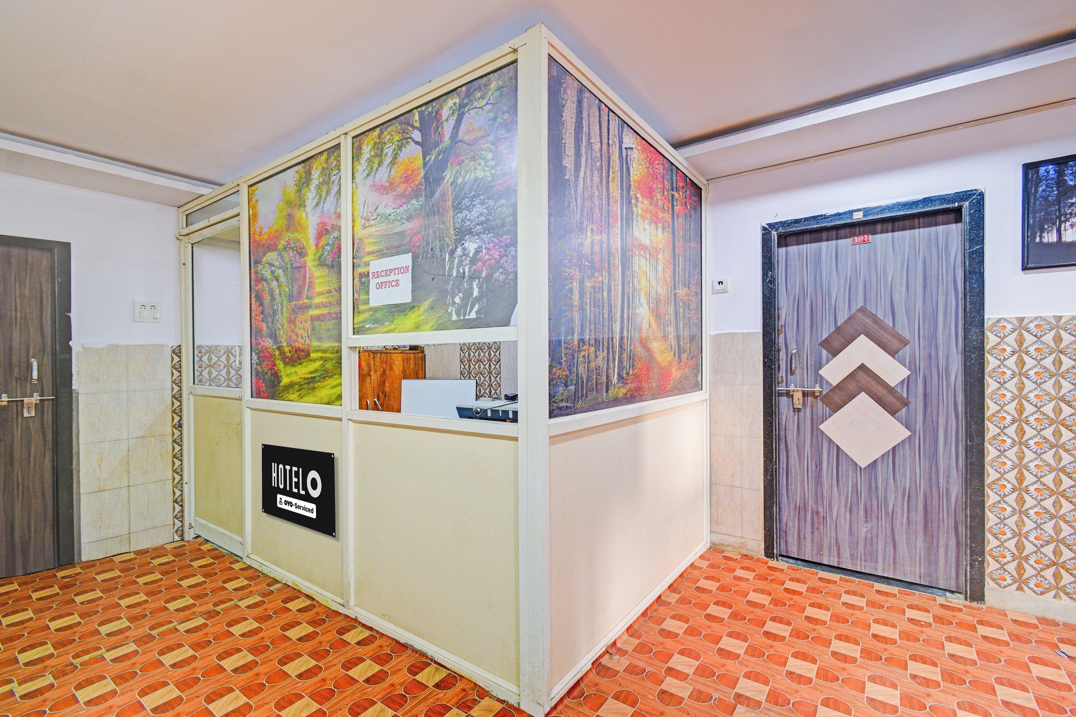 Un área de recepción con un cartel que indica una oficina, un letrero de hotel y una puerta numerada con el 101.