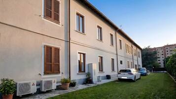 Un bâtiment à deux étages, doté d’un toit plat, de nombreuses fenêtres et d’une allée pavée.