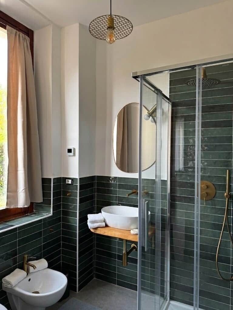 Une salle de bain moderne avec une douche à parois de verre, un lavabo blanc et un bidet.