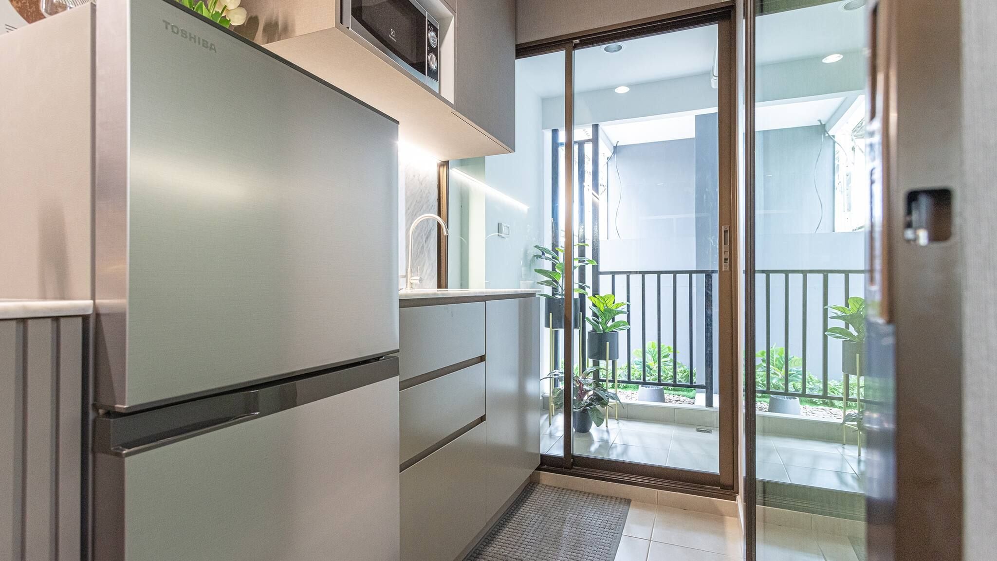 A compact kitchen with a built-in refrigerator, a sink, and a small countertop.
