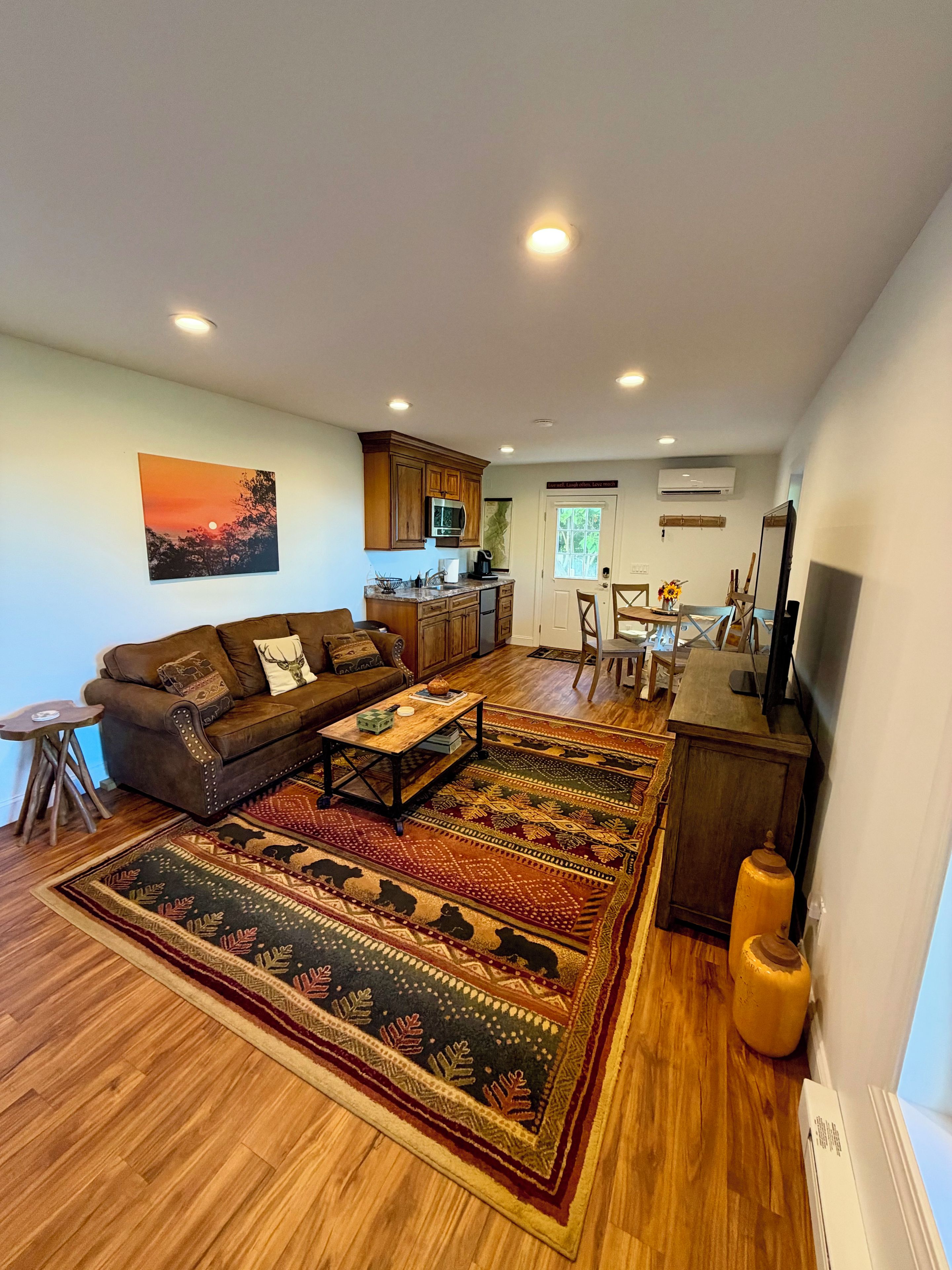 A living room with a sofa, coffee table, and a patterned rug.