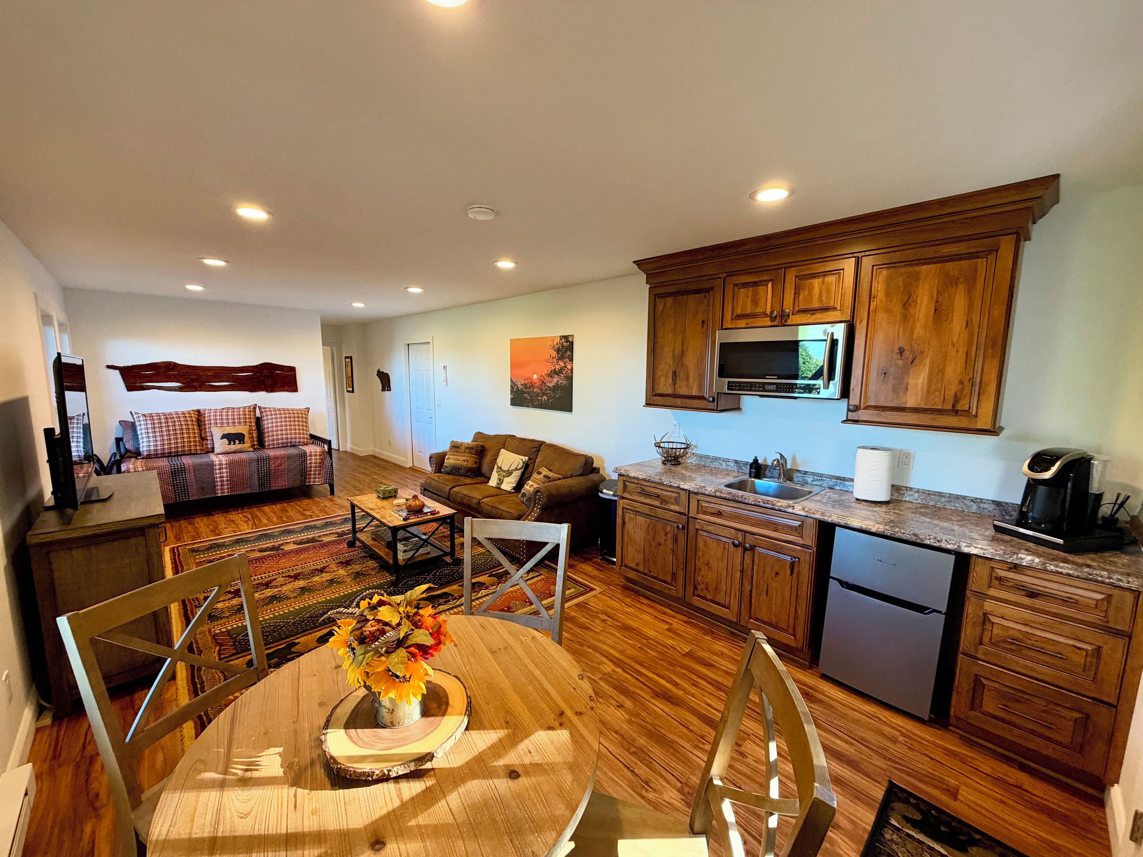 A modern kitchen with wooden cabinets, a stainless steel refrigerator, and a built-in microwave.