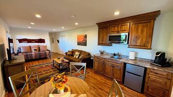 A modern kitchen with wooden cabinets, a stainless steel refrigerator, and a built-in microwave.
