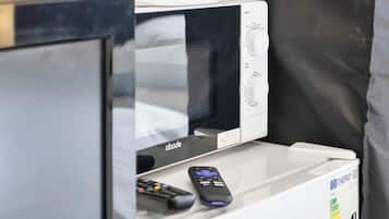 A kitchenette with a microwave, toaster, and a small refrigerator.