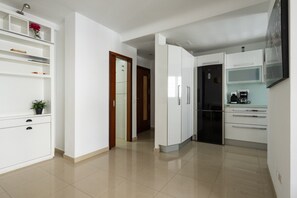 A modern kitchen with white cabinetry, a coffee maker, and a refrigerator. - DA CESAR | Spacious Stay near Maspalomas (El Tablero)