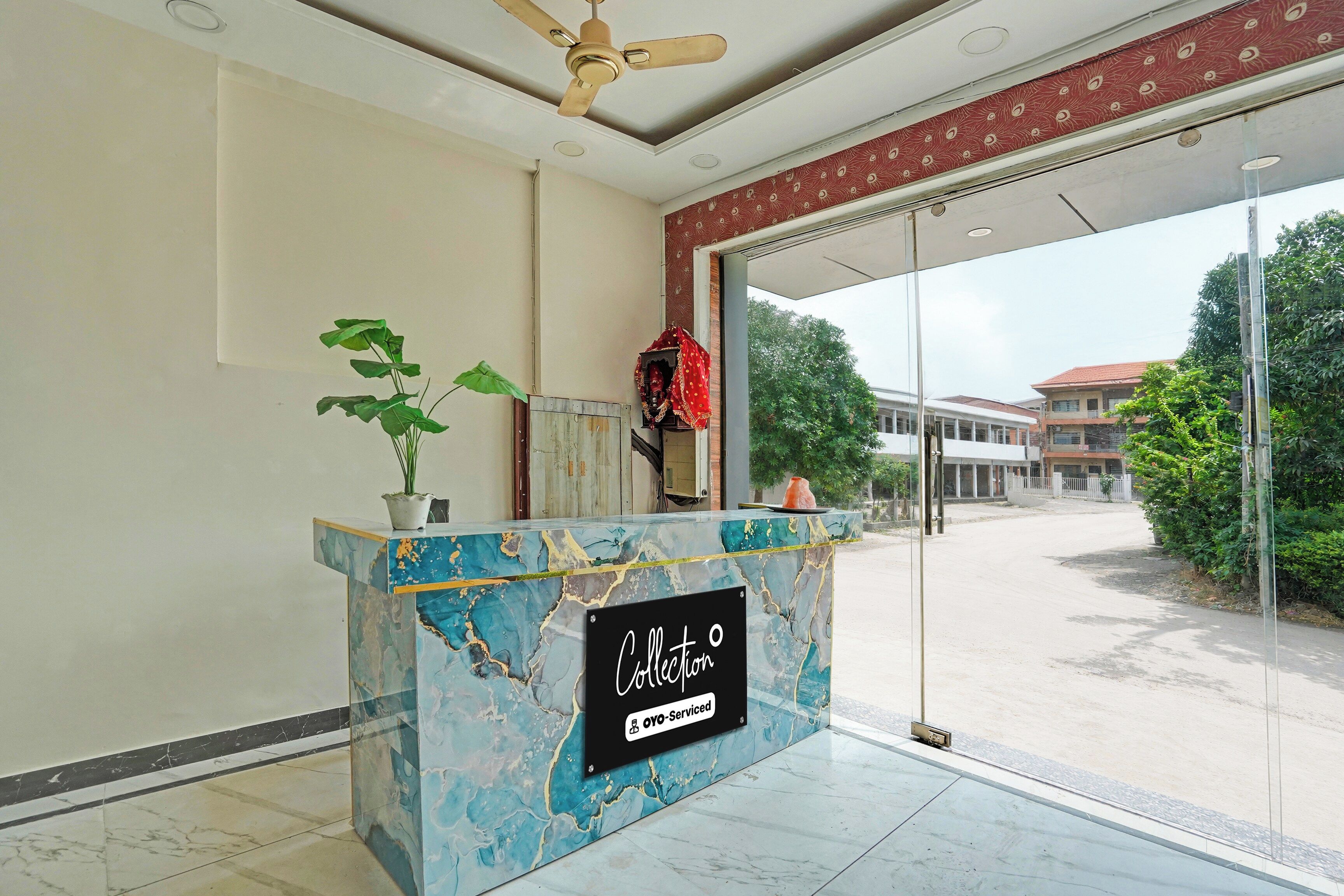 A reception desk with a marble top, a ceiling fan, and a view of the outside.