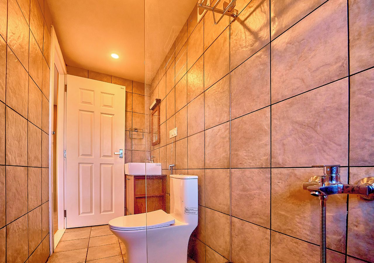 A bathroom with a toilet, a shower, and a sink.