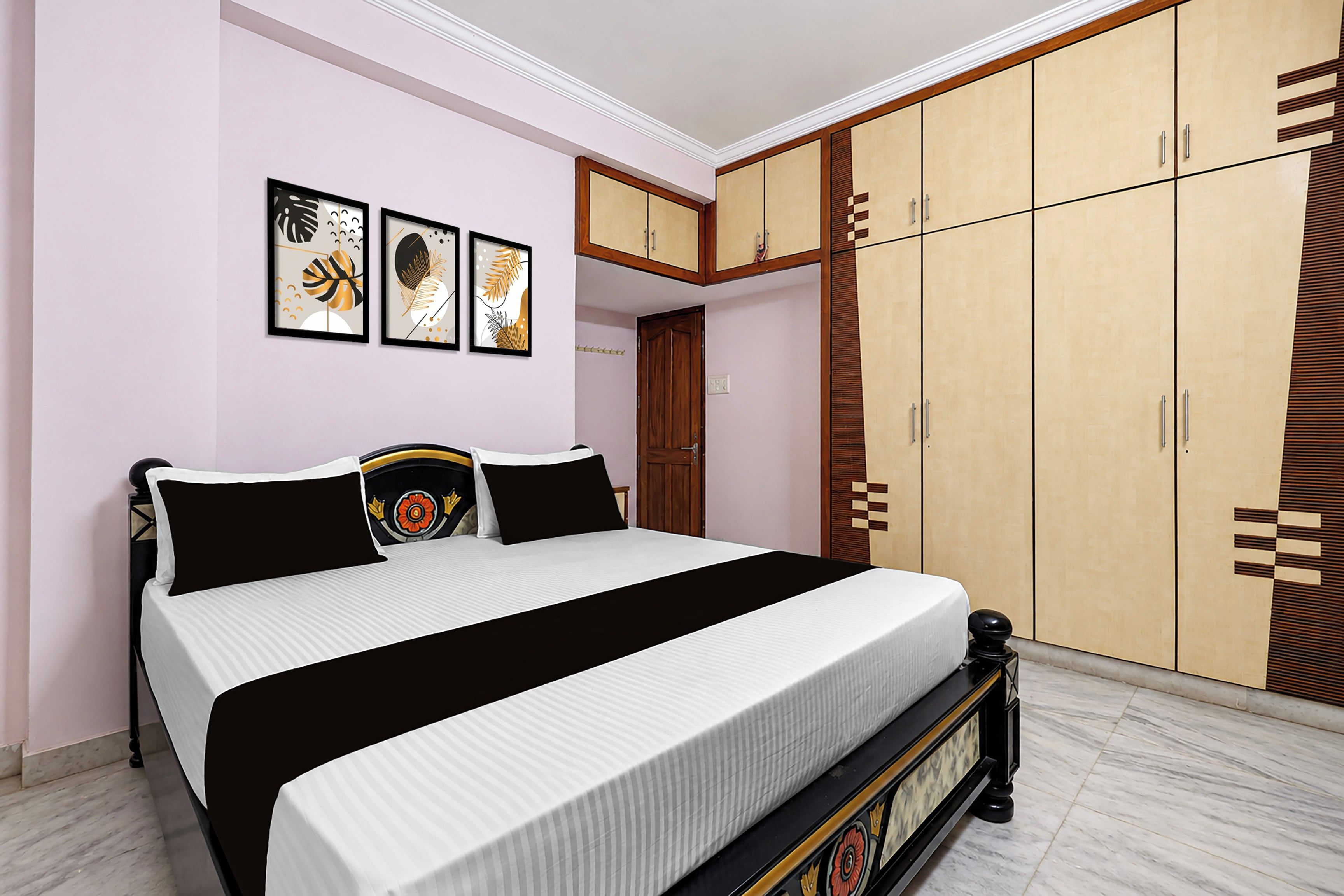 A bedroom with a bed, a wardrobe, and wall art.