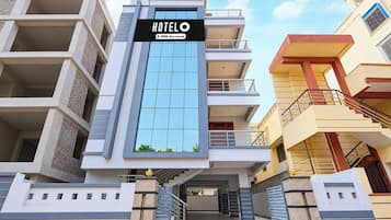 A modern hotel building with a prominent sign, multiple balconies, and a central entrance.