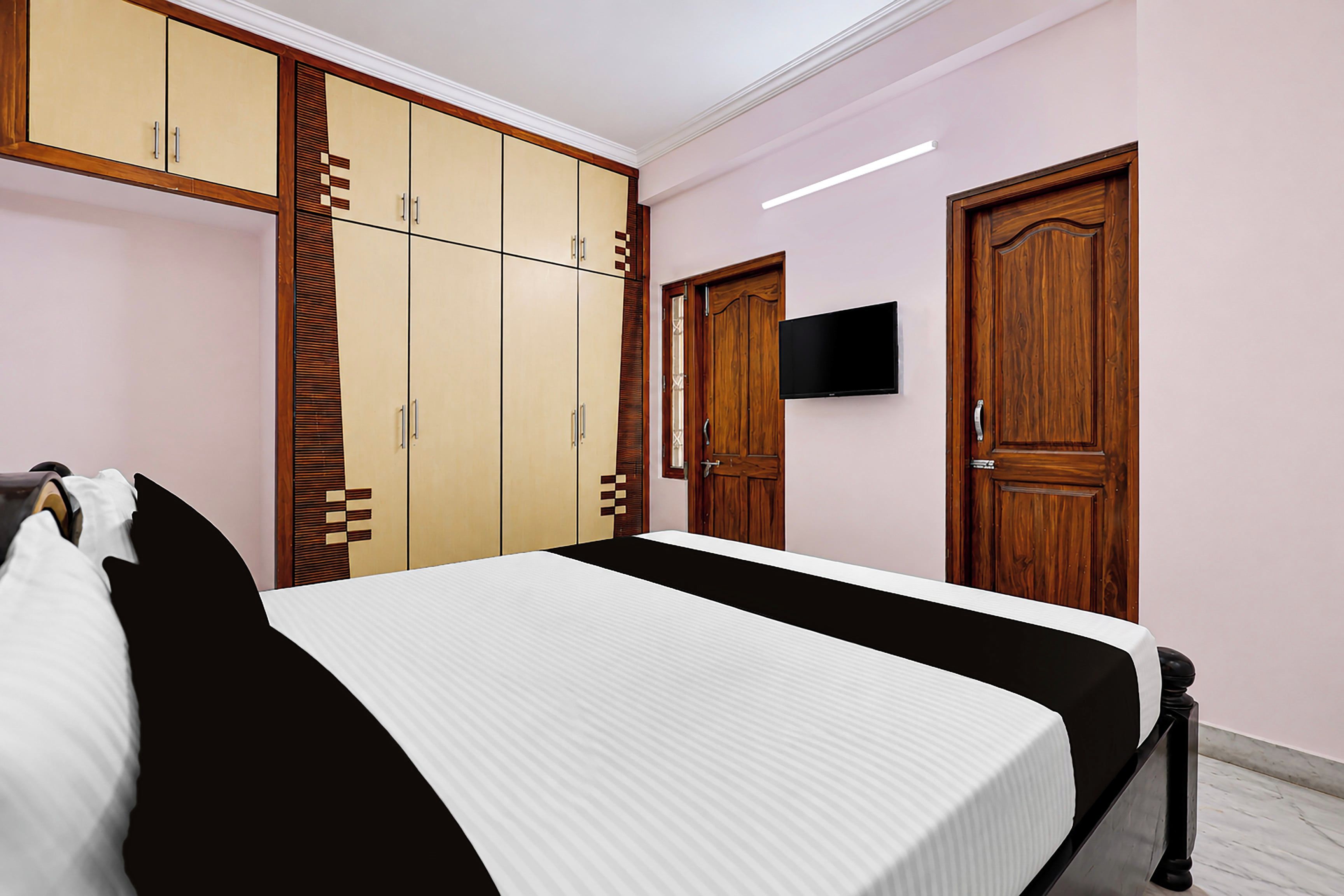 A bedroom with a bed, wardrobe, and a television.