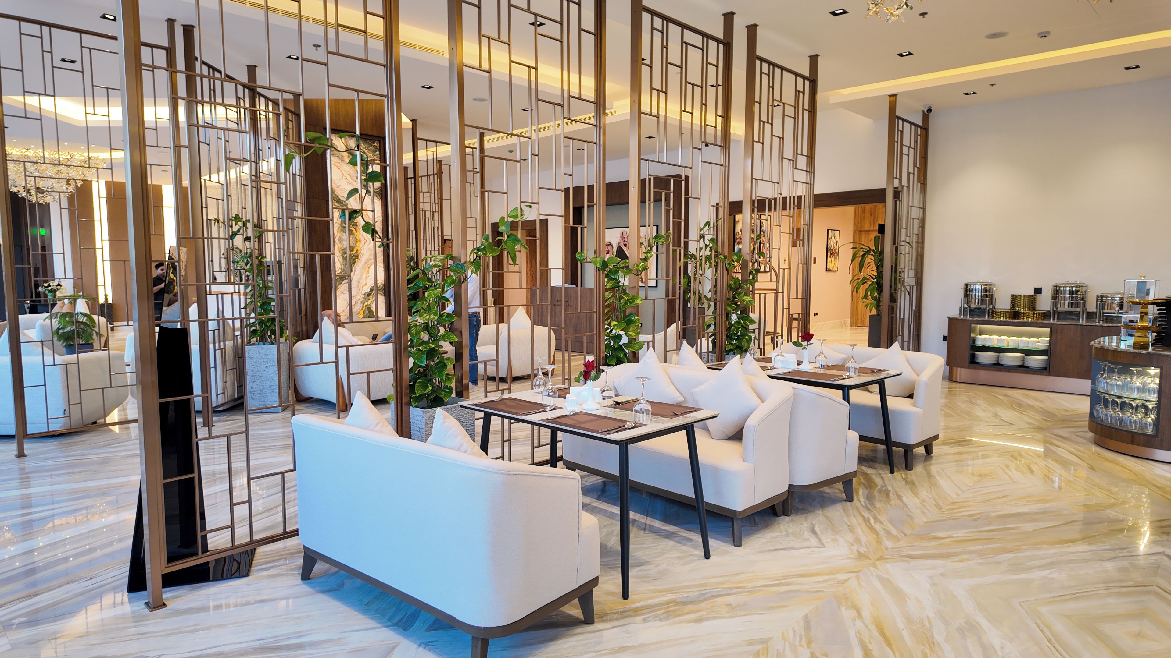 Eine moderne Hotelhalle mit Sitzgelegenheiten, einer Rezeption und Zimmerpflanzen.