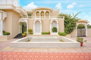 A building with a central courtyard, a staircase leading to an upper level, and a gated entrance.