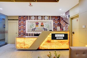 Una mesa de recepción con un letrero que dice 'PALETTE' y un reloj encima.