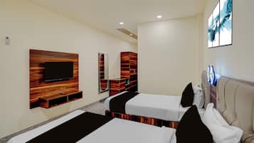 A hotel room with two beds, a TV mounted on a wooden panel, a mirror, and a painting on the wall.
