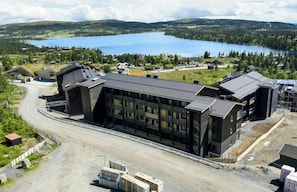A modern building with a large entrance and a view of a lake in the background. - Modern apartment with sauna by Sjusjøvannet (Sjusjøen)