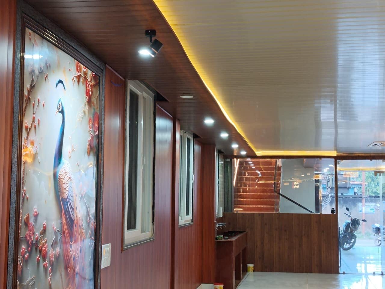 Un interior moderno con paneles de madera, un mural de pavo real y una escalera.