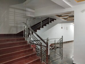 Un escalier avec une rampe métallique menant à un palier.