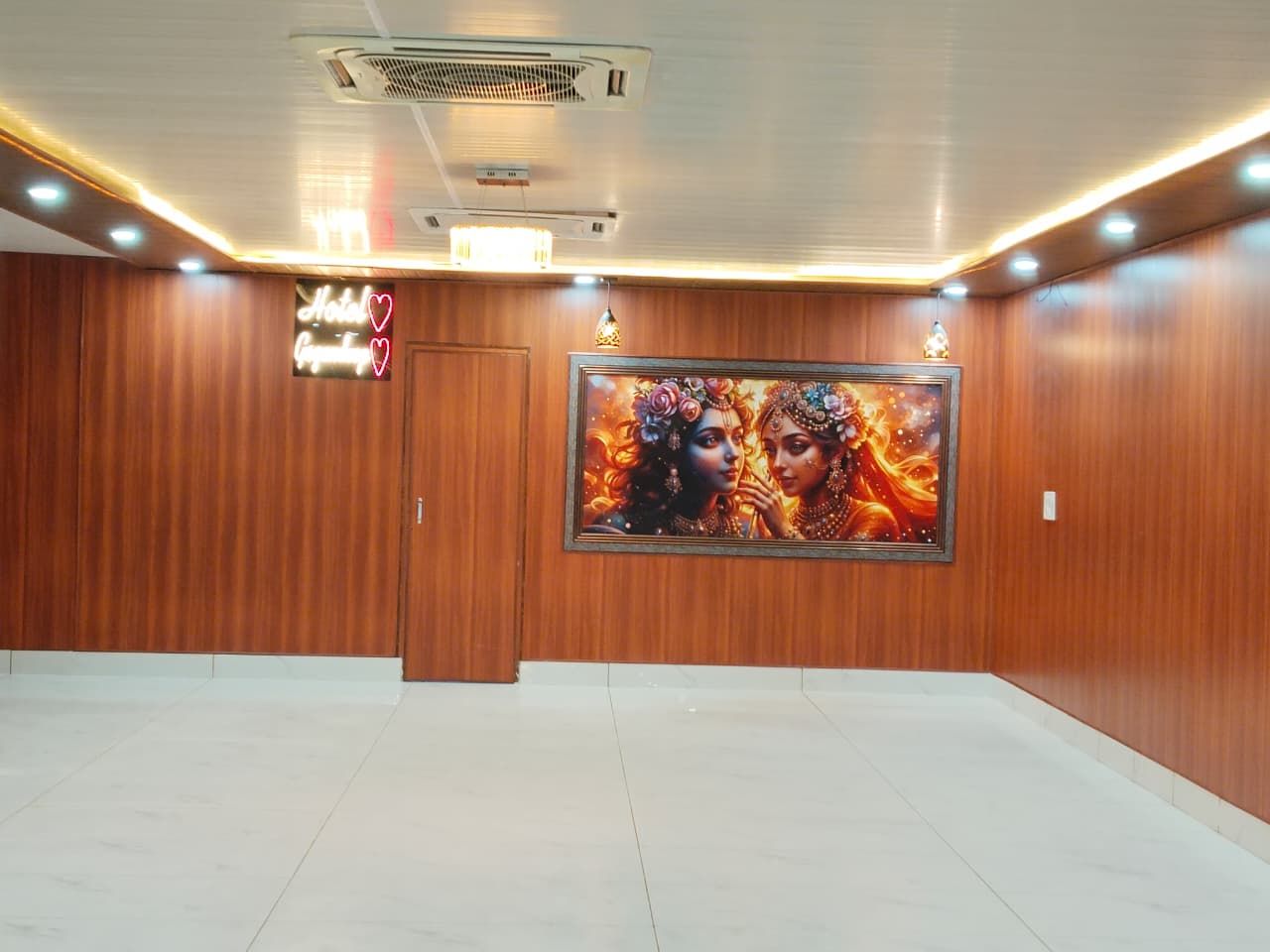 Un vestíbulo de hotel con paneles de madera, una obra de arte enmarcadas y un letrero de neón.