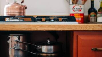 Una cucina con un forno tostatutto, una pentola di rame e diversi utensili da cucina sul piano di lavoro.