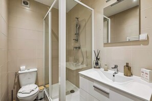 Ein modernes Badezimmer mit Toilette, Dusche und Waschtisch.