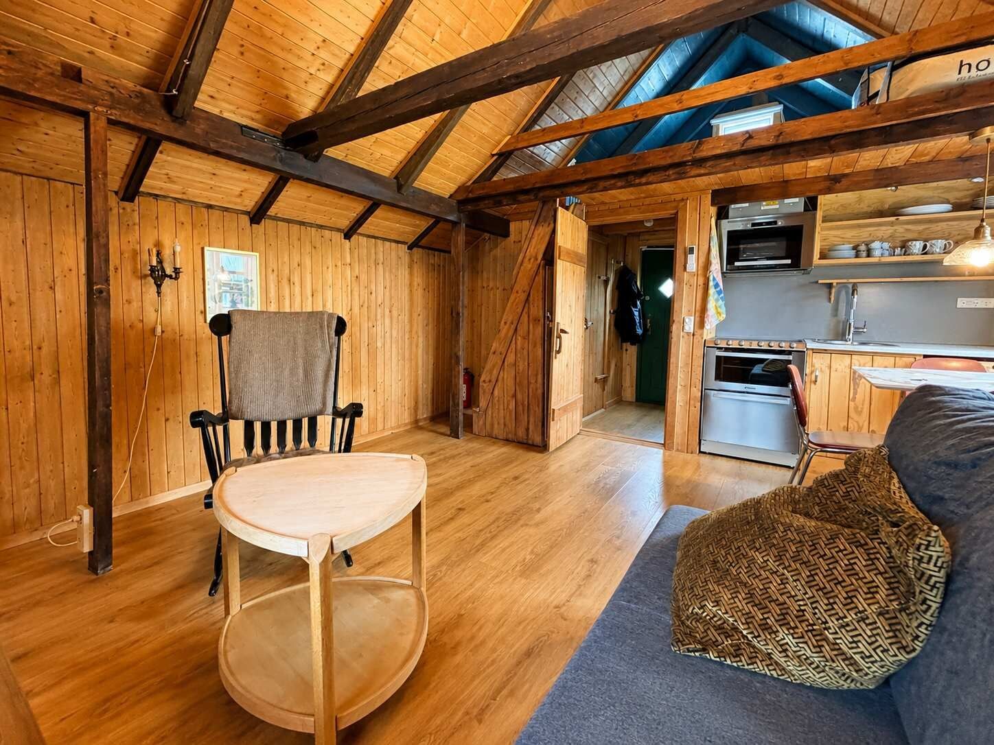 Un interior rústico de madera con comedor, cocina y un rincón de estar acogedor.
