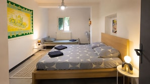 Une chambre à coucher avec un lit, une table de chevet avec une lampe, un radiateur et une fenêtre.
