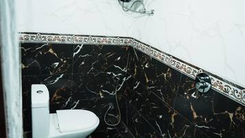 Une salle de bain avec des toilettes, une douche et un lavabo.