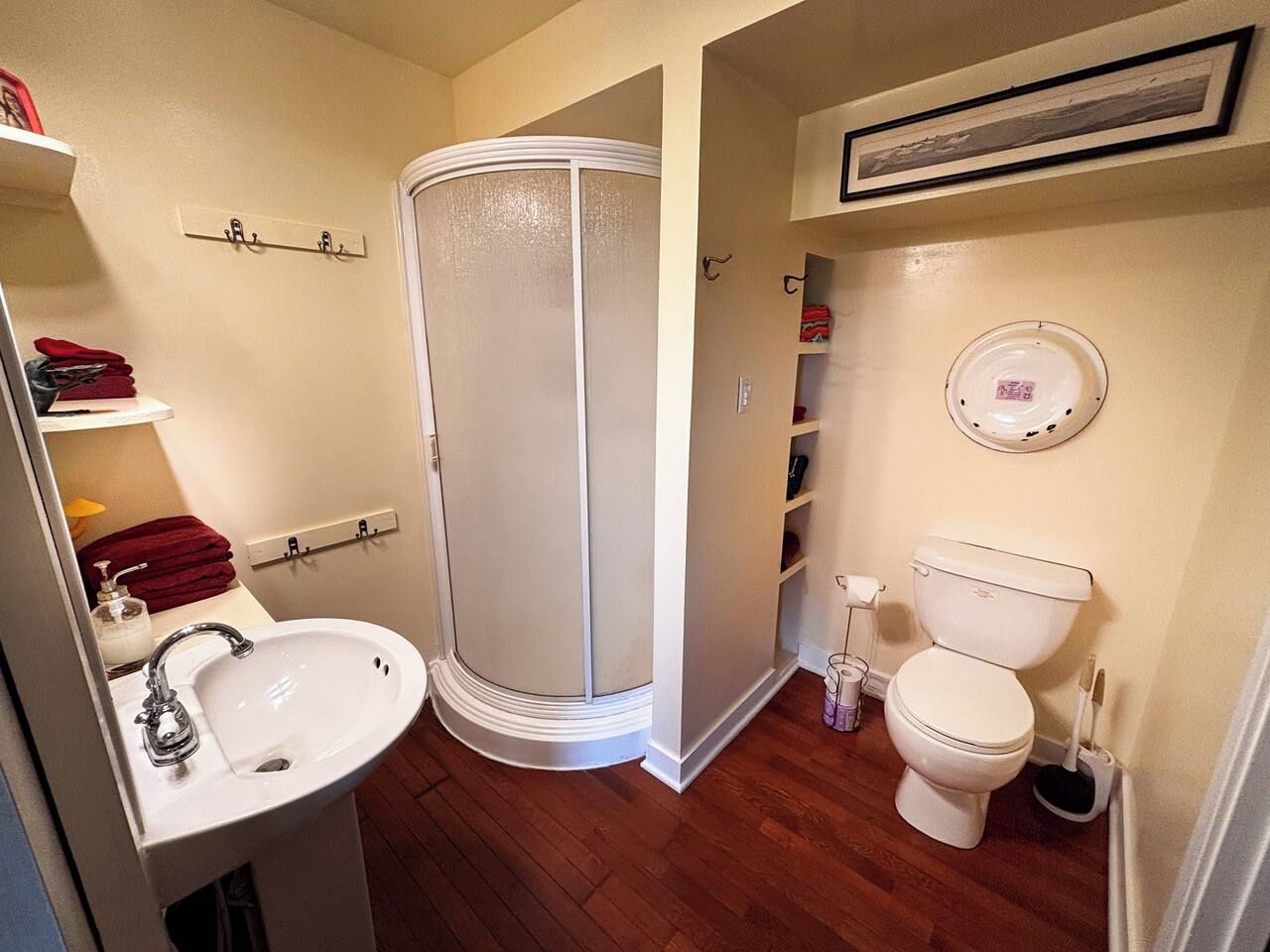 Une salle de bain équipée d’une douche, de toilettes, d’un lavabo et d’étagères.
