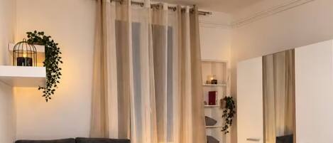 A modern bedroom with a bed, bedside tables, a ceiling fan, and a wardrobe.