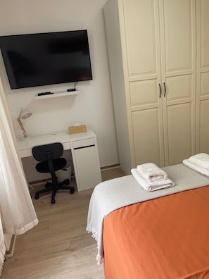 A bedroom with a bed, a desk with a chair, a television, and a wardrobe. - Charming 2-room apartment in Nice. Comfortable, cozy, and close to the sea (Nice)