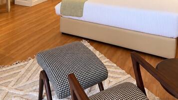Un dormitorio con una cama grande, un armario, una mesita de noche y una silla.