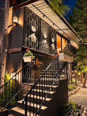 A staircase with a metal railing leading to a balcony with potted plants.
