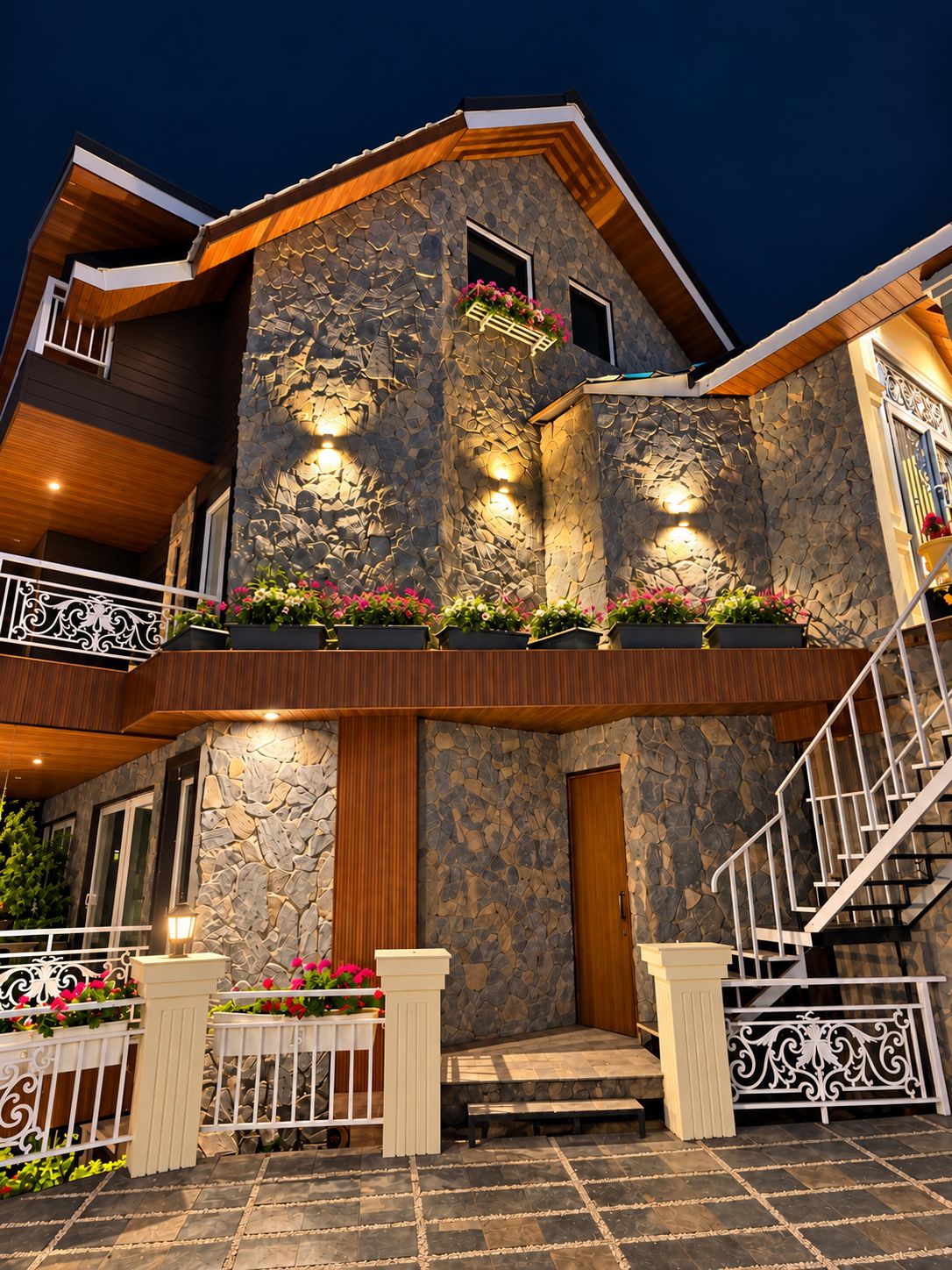 Une maison à plusieurs étages avec une façade en pierre, un balcon doté de balustrades et un escalier menant à l’étage supérieur.
