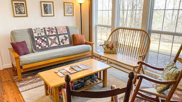 A cozy living room with a sofa, a coffee table, and two rocking chairs.