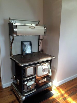 A vintage stove with a metal top and a framed picture on the front.