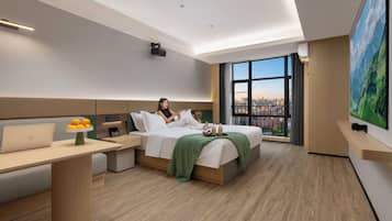 A modern hotel room with a bed, a desk, a chair, and a large window offering a city view.