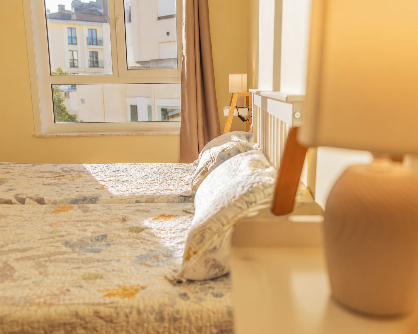 Un dormitorio con una cama, una ventana y una lámpara.