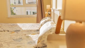 Un dormitorio con una cama, una ventana y una lámpara.