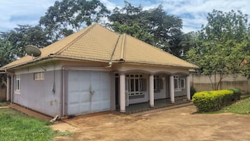 A single-story house with a tiled roof, a covered porch, and a garage.