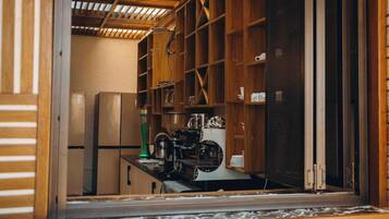 A kitchen with wooden cabinets, a stainless steel refrigerator, and a coffee machine.